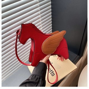 Close-up of red pegasus crossbody bag with brown leather wings and tassel tail details