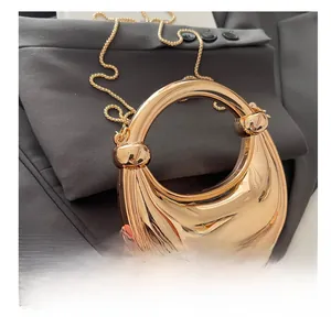 Close-up of golden crescent moon acrylic dinner bag with metallic handle and chain