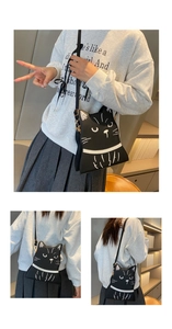 Close-up of black cat crossbody bag featuring detailed white embroidery and adjustable strap