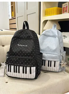 Detail view of black and blue polka dot backpacks with piano key prints and star charms