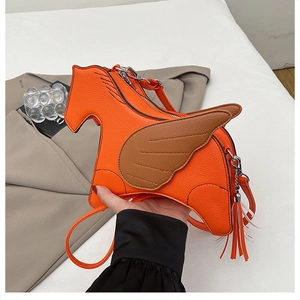 Detail of creative horse-shaped crossbody bag with orange fringes and litchi texture