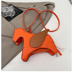 Detail of orange pony-shaped crossbody bag with wing decor and colorful tassel tail
