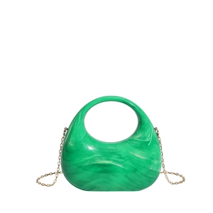 Detail view of emerald green marble acrylic handbag with golden metal chain strap