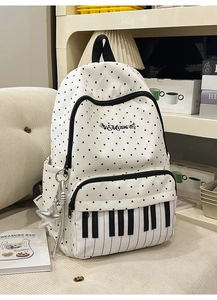 Detailed view of music-themed backpack with piano keyboard print and polka dot pattern
