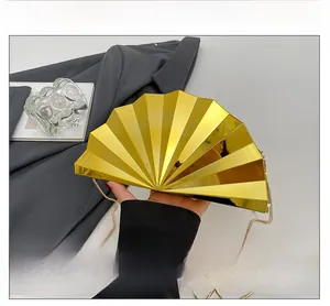 Detailed macro view of the gold folding fan shaped evening clutch bag with metal chain