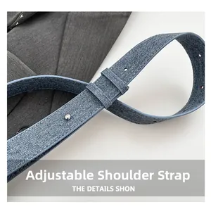 Nahaufnahme des verstellbaren Schultergurts aus blauem Denim-Stoff mit Metallschnallen
