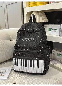 Detail of polka dot backpack with piano key pocket and Music embroidery on white sofa