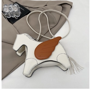 Detail of horse-shaped crossbody bag with white leather texture and brown wing accents
