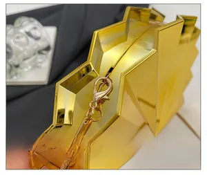 Close-up of golden fan-shaped evening bag featuring premium hardware and snake chain