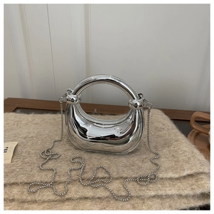 Detail of silver mirror crescent bag with metal ball chain on wool texture fabric