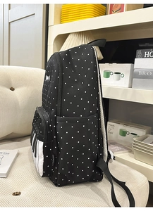 Detail of creative piano keys front pocket on a black polka dot school backpack