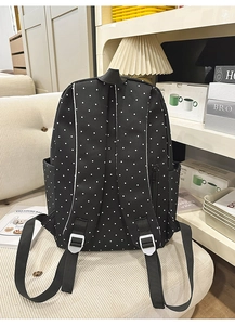 Detailed back view of polka dot backpack with adjustable straps and side zipper pocket