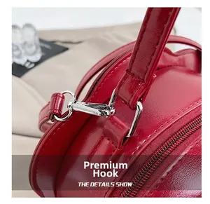 Detail of premium silver metal hooks and red litchi texture leather on the round bag