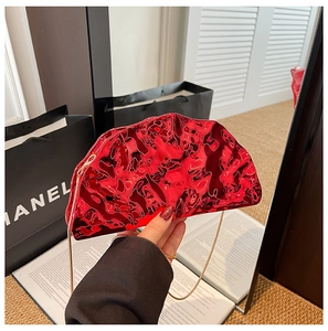 Dettaglio della borsa da sera a mezzaluna in acrilico rosso metallizzato con catena dorata