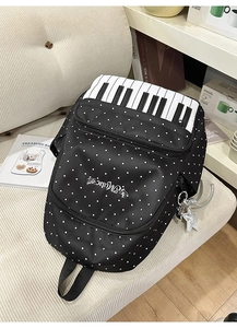 Close-up of black polka dot backpack featuring creative piano key flap and music embroidery