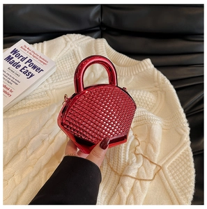 Close-up of a mini red rhinestone evening clutch bag with chain strap and metallic handle
