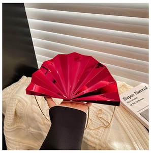 Detailed close-up of fuchsia metallic fan-shaped clutch with gold chain strap