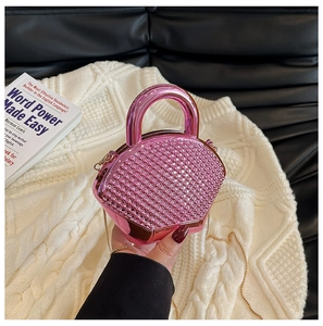 Detail of pink rhinestone mini evening bag with a metal handle and gold chain strap