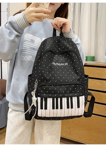 Detail of black polka dot backpack with piano keyboard design and music embroidery