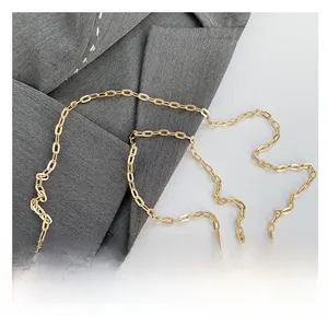 Detailed close-up of polished golden chain strap and mirror acrylic surface on the handbag