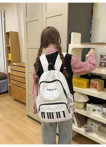 Detail of polka dot backpack with piano key print and a cute star metal charm
