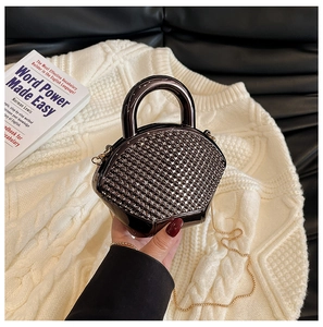 Detail of a fan-shaped black metallic evening clutch with circular 3D beaded texture