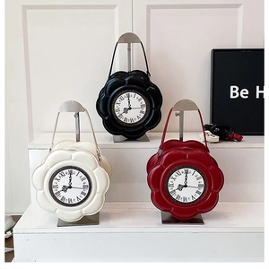 Chic flower-shaped clock purses in cream, black and wine red on display stands