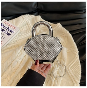 Close-up of sparkling silver rhinestone shell clutch with metal handle and chain strap