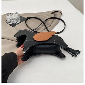 Detail of creative horse-shaped crossbody bag featuring black lychee pattern PU leather and tassels