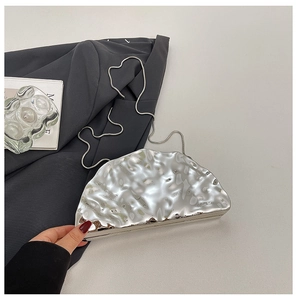 Dettaglio ravvicinato della borsa da sera in acrilico argento con texture metallo liquido
