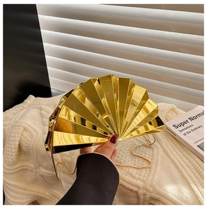 Detailed close-up of a fan-shaped gold evening clutch with a polished metallic mirror finish