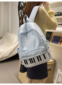 Detail of light blue polka dot backpack featuring piano keyboard pattern and star charm