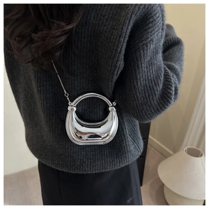 Chic silver mirror crescent mini bag shown on person with metal round handle and chain