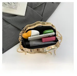 Detailed internal view of golden wave evening bag showing storage space for phone and makeup