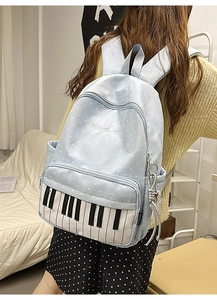 Close-up of light blue polka dot backpack with creative piano keyboard pocket and embroidery