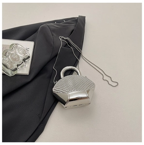 Detail of silver shell clutch with shimmering rhinestones and sleek mirror finish