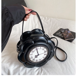 Close-up of vintage clock-shaped crossbody bag with floral design and Roman numerals