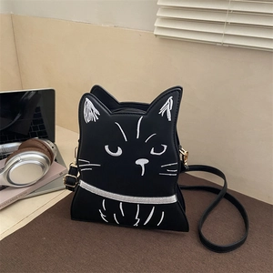 Chic black cat shaped crossbody bag with white embroidery on a minimalist desktop