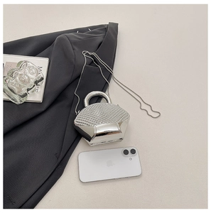 Detailed view of silver shell evening bag with rhinestones and metal chain strap