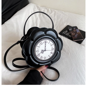 Detail of flower-shaped black clock purse with Roman numerals and top handle on a table