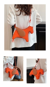 Detail of orange Pegasus shaped crossbody bag with lychee texture leather and tassel tail