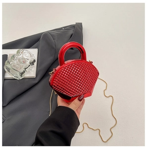 Close-up of red beaded fan-shaped evening clutch bag with round handle and gold chain