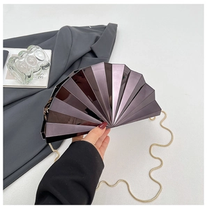 Detail of fan-shaped purple and black metallic clutch with golden snake chain strap