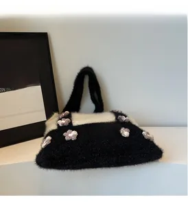 Detail of knit handbag featuring black and white plush fabric with crochet flower accents