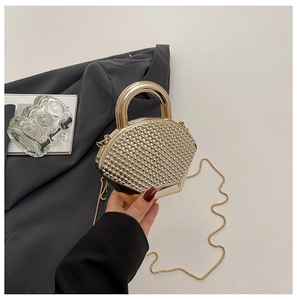 Close-up of golden fan-shaped evening bag with shimmering rhinestones and ring handle