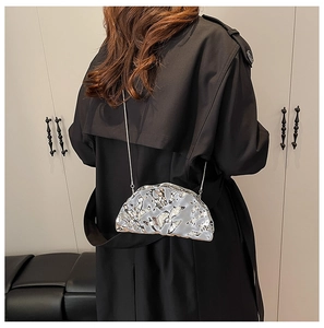 Dettaglio della borsa a tracolla argento metallizzato con design increspato e catena sottile