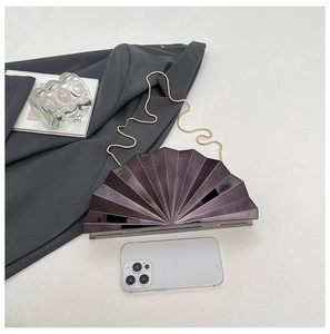 Detailed close-up of fan-shaped hard shell evening clutch with gold chain strap