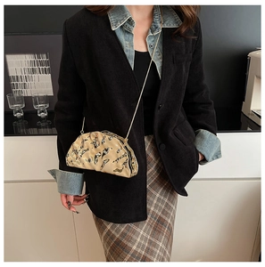 Modella con borsa da sera in acrilico con stampe astratte e tracolla a catena d'oro