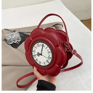 Detail of red flower-shaped handbag with vintage clock face and roman numerals