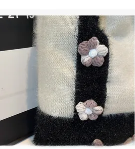 Détail du sac tricoté doux avec fleurs crochetées en 3D et texture épaisse au style rétro